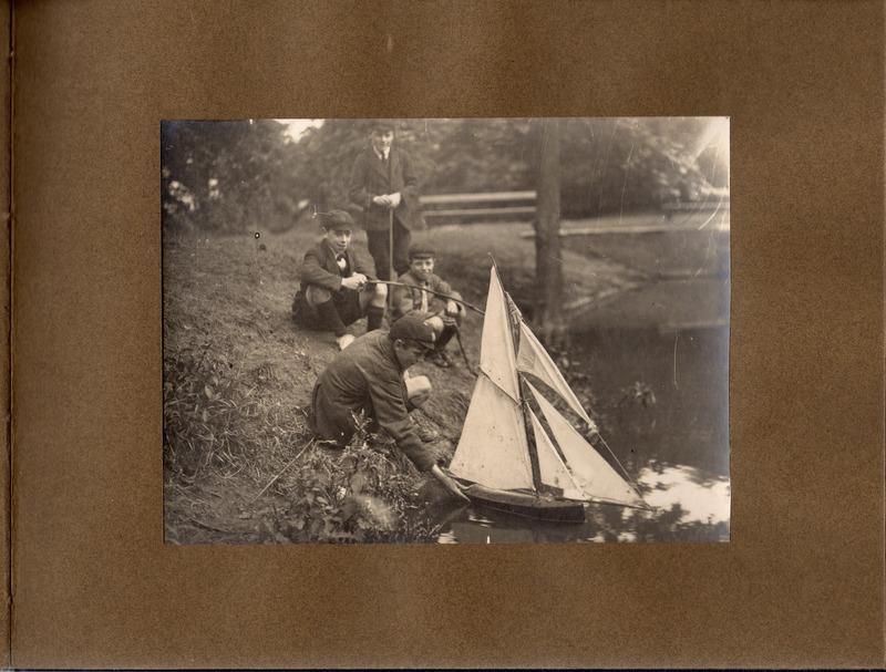 F1a-134: Northcliffe Woods 1920: Page 6 - 4 young people at waterside launcing a model sail boat. Image credit: Saltaire Collection