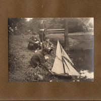 F1a-134: Northcliffe Woods 1920: Page 6 - 4 young people at waterside launcing a model sail boat. Image credit: Saltaire Collection