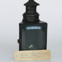 E1a-083: Porter's lamp: Front view with explanatory card. Digital image credit: Saltaire Collection